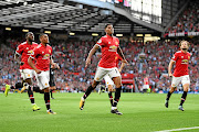 Manchester United forward Marcus Rashford celebrates with teammates after scoring.        