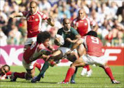 SANDWICHED: South Africa's JP Pietersen escapes tackles of Tonga's Finau Maka, left, Sione Tu'Ipulotu, right, in the Rugby World Cup Group A match on Saturday. The Boks won 30-25. Pic. Julien Behal. 22/09/07. © AP.