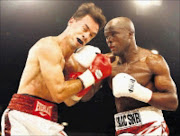 TAKE THAT! American Devlin Rodriguez, left, is punished by Isaac Hlatswayo during thier IBF welterweight eliminator at Emperors Palce in Ekurhuleni on Monday.  18/11/2008. Pic. Antonio Muchave.  © Sowetan.