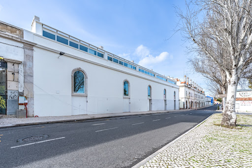 Prestige property for sale in Lisbon (Portugal) - White building facade, arched windows, paved street