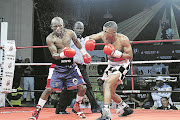 Sivenathi Nontshinga (black and white trunks) connects with a right hook en route to his ninth round TKO of Siyabonga Siyo at Orient Theatre.