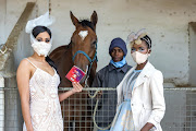 Models Julia Petersen (left) wearing a Hanrie Lues designed outfit and  Noluthando Dube dressed by Madelain Clark, pictured with groom Dumisani Bonani. 