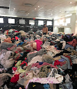 A volunteer stands thigh-deep in donations meant for those who lost their homes and belongings in the fire.