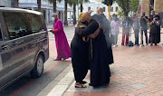 Archbishop Emeritus Desmond Tutu's daughter, Thandeka, embraces the dean of St George's Cathedral in Cape Town, the Rt Rev Michael Weeder, after arriving with her father's  coffin on December 30 2021.