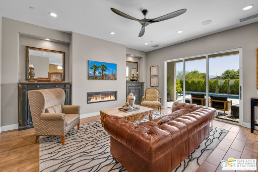Modern living room with fireplace and pool access - Buy this luxury house in Palm Desert, 4 bedrooms