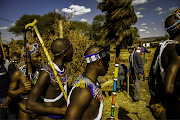 The initiates emerge from the boma, watched by the elder men. This is their 'coming out', a cause for great celebration in the community.