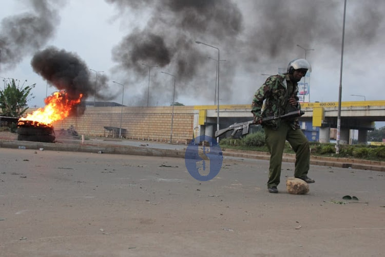 A police officer removes a stone from the road as chaos erupt at Kondele in Kisumu after the IEBC Chairman Wafula Chebukati declared Deputy President William Ruto as the President-elect on August 15, 2022.