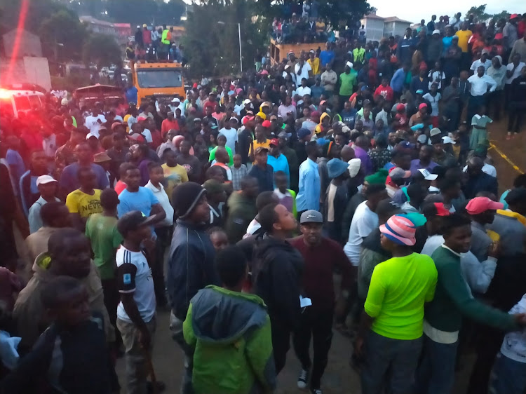 Murang'a town residents mill around the collapsed building as search and rescue operations continue, Monday, June 19, 2023.