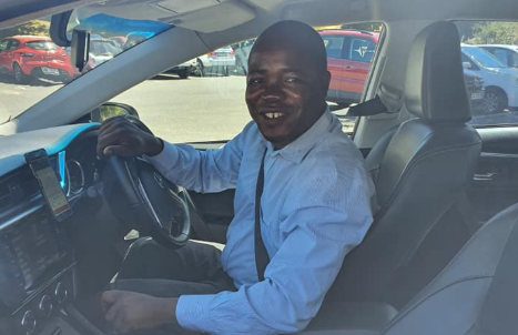 Omar Ndayishimiye, a refugee who worked as a car guard in Cape Town, in the car he bought with all his tips. He now works as an Uber driver.