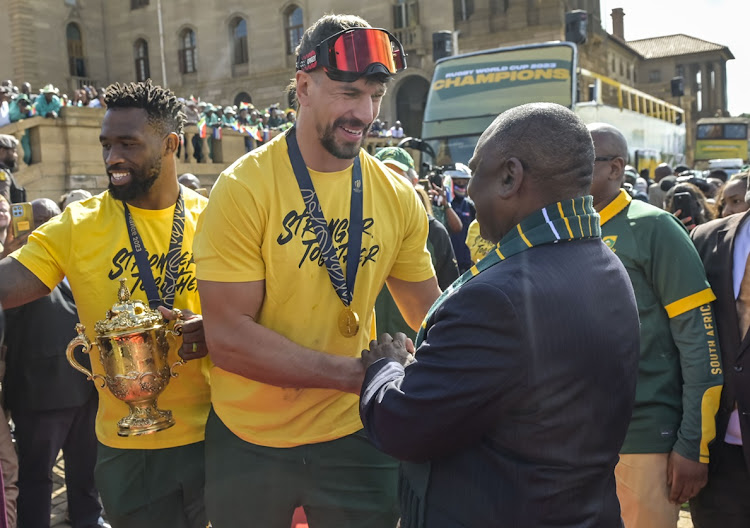 Springbok captain Siya Kolisi (left) and teammate Eben Etzebeth present the Webb Ellis Cup to President Cyril Ramaphosa at the Union Buildings in Pretoria during the Springboks' Rugby World Cup 2023 trophy tour on November 2.