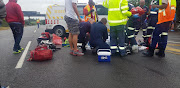 Paramedics treat a critically injured cyclist who was hit by a minibus taxi on the M4 Ruth First Freeway near Umdloti, north of Durban, on Sunday. 