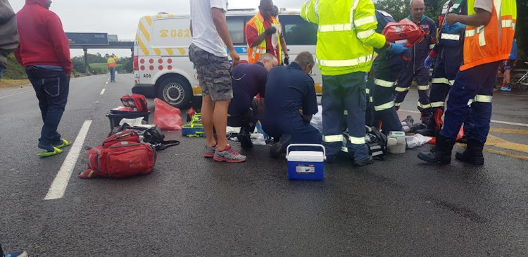 Paramedics treat a critically injured cyclist who was hit by a minibus taxi on the M4 Ruth First Freeway near Umdloti, north of Durban, on Sunday.