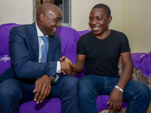 SportPesa CEO Ronald Karauri shakes hands with SportPesa Mega Jackpot winner Samuel Abisai when he went to pick him up at their TRM house. photo/PATRICK VIDIJA