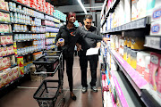 Checkstar employees pack groceries for customers waiting outside in the parking lot.