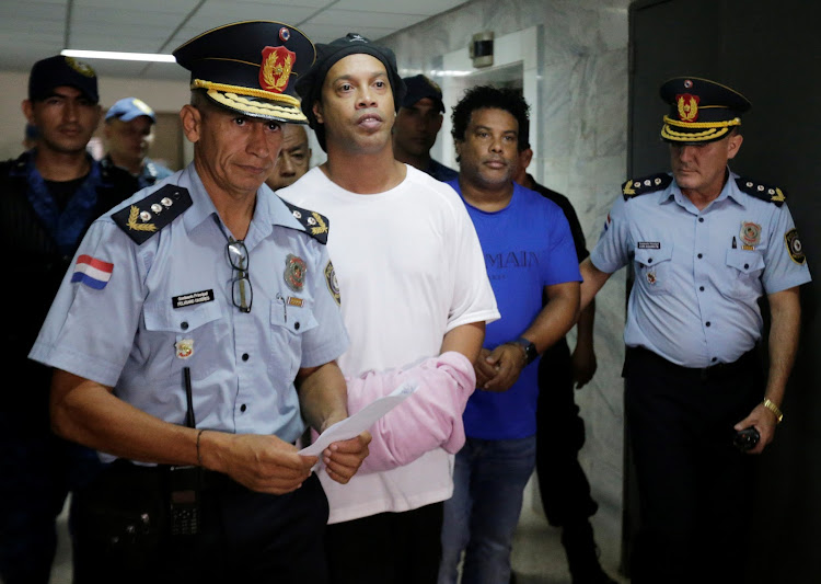 Ronaldinho and his brother Roberto de Asis handcuffed and escorted by police at the Supreme Court of Paraguay on March 7 2020. Judge ruled Ronaldinho must remain in Paraguayan jail until further notice.