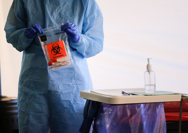 A nurse holds a completed test with patient samples at a drive-through testing site for coronavirus, flu and RSV.