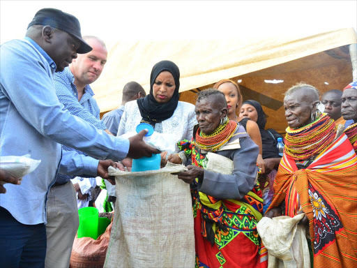 Ahadi Kenya Trust CEO Stanley Kamau, Lotto Kenya chairman Shane Leahly and Isiolo governor’s wife Madina Doyo during the Chakula Kwa Wote food distribution project in Chumvi Yere, Isiolo, yesterday / ANTHONY NJOROGE