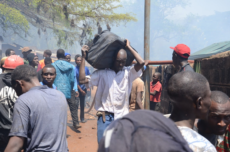 A resident of Depsea Slum with his personal belongings after a the fire outbreak.