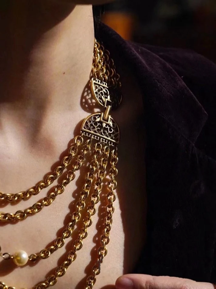 Collier vintage multi-rangs avec perles et pompons. Accessoire parfait pour un look rétro et élégant, idéal pour toutes les occasions.