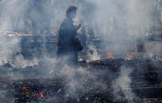 A woman wearing a protective mask, amid the coronavirus disease (COVID-19) outbreak, prays as she walks across smouldering hot ground at the fire-walking festival, called hiwatari matsuri in Japanese, at Mt.Takao in Tokyo, Japan, March 14 2021. 