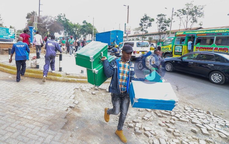 A businessman carries boxes for learners as schools officially reopen for their first term on January 2023 education calendar on January 24, 2023