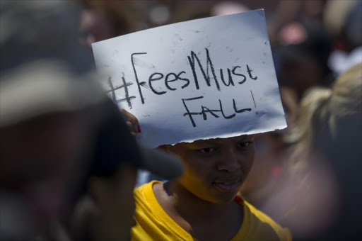 South African students protest outside the parliament precinct before forcing their way through the gates of parliament on October 21, 2015 in Cape Town, South Africa. Protesting students broke through the gates of parliament during protests against a proposed hike in tuition fees, this is part of the #FeesMustFall movement. File photo