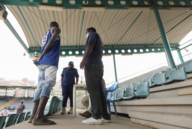 A COVID-19 rule breaker stands before an official during an interrogation at Eagle Square in Abuja, Nigeria, in this recent picture.