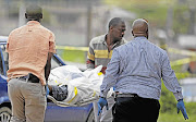 The body of IFP member Siya Dlamini is removed after he was shot dead outside the Ntuzuma Magistrate's Court. File photo.