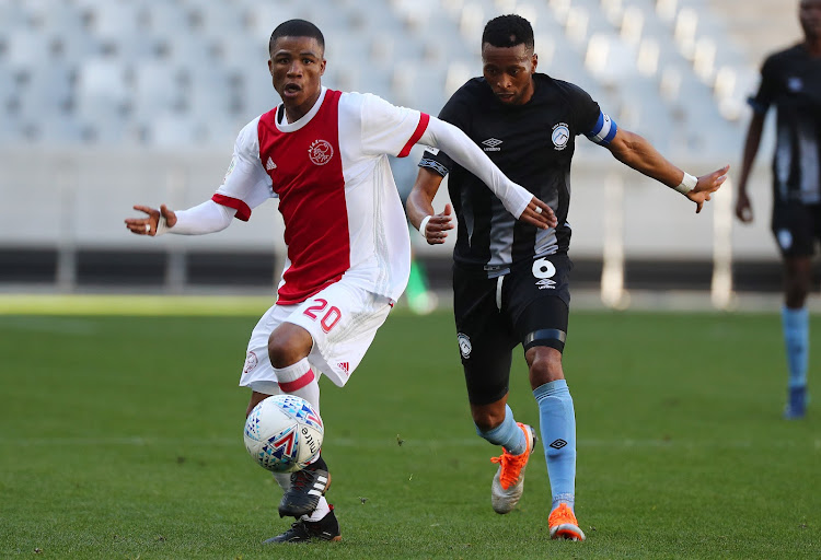 Samuel Julies of Ajax Cape Town evades challenge from Molemo Mekoa of Cape Umoya United FC during the National First Division 2018/19 football match between Cape Umoya United and Ajax Cape Town at Cape Town Stadium, Cape Town on August 28 2018.