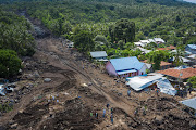 An aerial picture shows houses damaged by landslides triggered by tropical cyclone Seroja in East Flores, East Nusa Tenggara province, Indonesia, on April 8 2021.