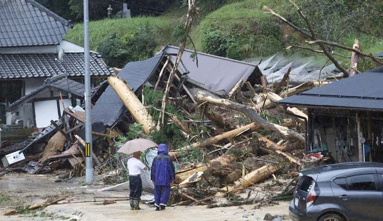 Local residents look at a landslide site caused by Typhoon Lan in Ayabe, Kyoto prefecture, western Japan August 15, 2023, in this photo taken by Kyodo.