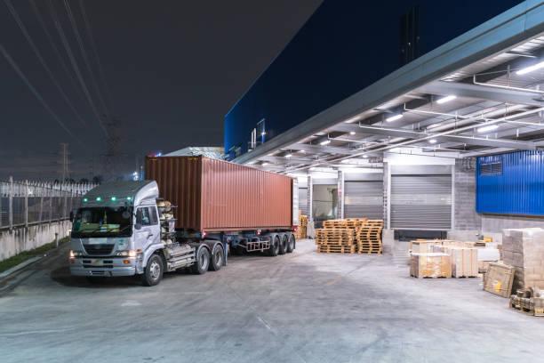 Truck is carrying container is parking in front warehouse at night time Truck is carrying container is parking in front warehouse at night time shipping container storage stock pictures, royalty-free photos & images