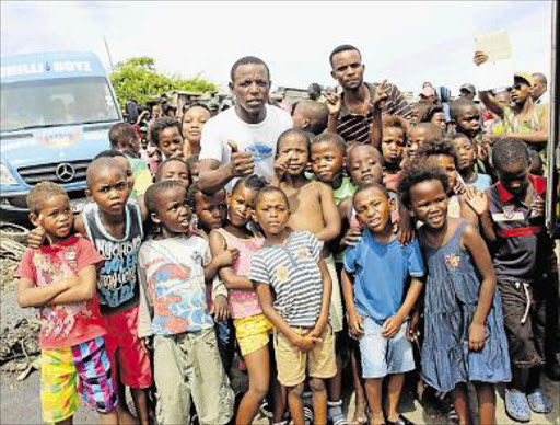 SPORTING CHANCE: The children from Sakhuluntu Child and Youth Centre in Duncan Village with founder of the centre (white t-shirt) Thembekile Havi, in centre wearing white shirt, during Chippa United’s visit on Friday. yesterday. Chippa United donated R25000