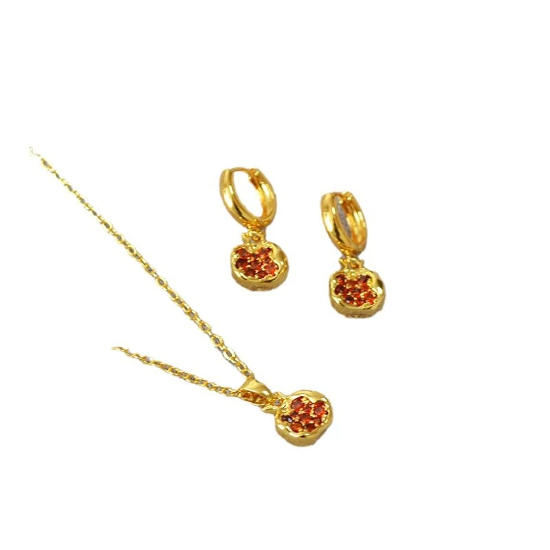 Collier et boucles d'oreilles grenade rouge plaqué or. Un ensemble chic et élégant pour rehausser votre tenue et vous faire briller.