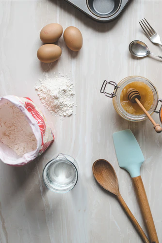 A photo of several ingredients needed to bake and some kitchen utensils. 