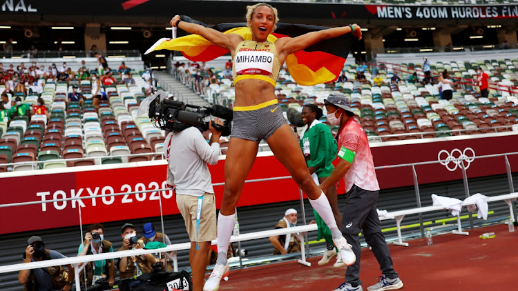 Malaika Mihambo of Germany celebrates with her national flag after winning gold in the women's long jump final at Olympic Stadium, Tokyo, August 3, 2021