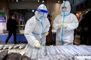 A staff member from the center for disease control and prevention collects a swab from a seafood stall for nucleic acid testing, at a market following the coronavirus disease (Covid-19) outbreak, in Taiyuan, Shanxi province, China January 20, 2021.  