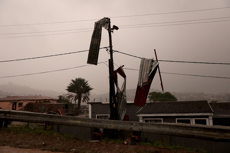 Pieces of a corrugated iron roof hang on the electricity street pole in Inanda, north of Durban, following heavy downpours. Picture: SANDILE NDLOVU