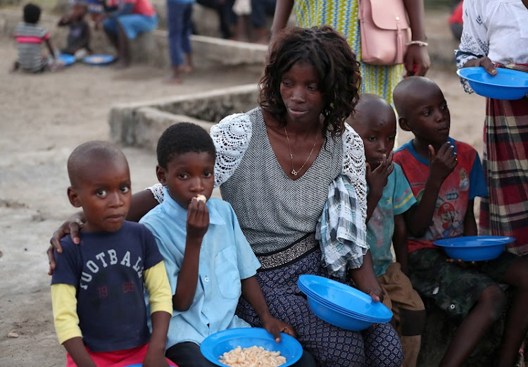 Virginia Samuel sits with two of her four children at a camp for people displaced in the aftermath of Cyclone Idai in Beira, Mozambique.