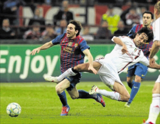 STALEMATE: Barcelona playmaker Lionel Messi is fouled by AC Milan's Alessandro Nesta during their Uefa Champions League quarterfinal first leg match at Stadio Giuseppe Meazza in Milan, Italy, last week. Photo: Getty Images