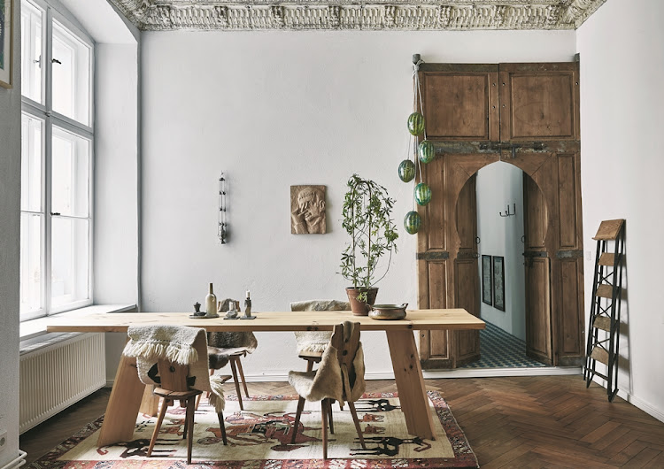 The large Berliner Zimmer is used as a dining room and kitchen; the Moroccan door that leads to the master bedroom was the first piece the owners purchased for their new home.