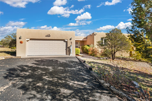 Beige house with garage and vegetation in this luxury property for sale in Santa Fe ($950,000)