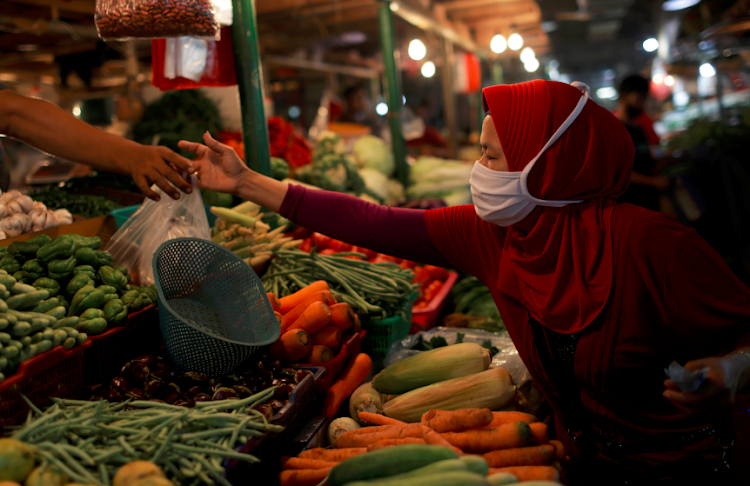 A woman wearing a protective mask shops for vegetables at a traditional market, as the coronavirus disease outbreak continues, in Jakarta, Indonesia on September 23, 2020.