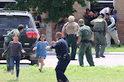 Children run to safety after escaping from a window during a mass shooting at Robb Elementary School where a gunman killed nineteen children and two adults in Uvalde, Texas, U.S. May 24, 2022. 