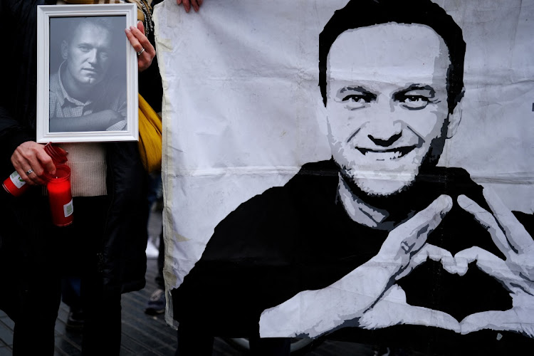 A woman holds candles at a portrait of late Russian opposition leader Alexei Navalny, in Barcelona, Spain, on February 25. Picture: NACHO DOCE/REUTERS