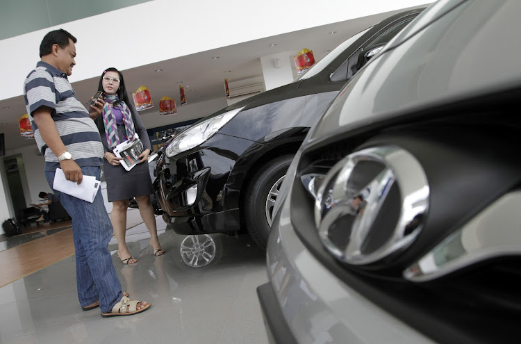 A salesperson talks to a customer at a Hyundai dealership.