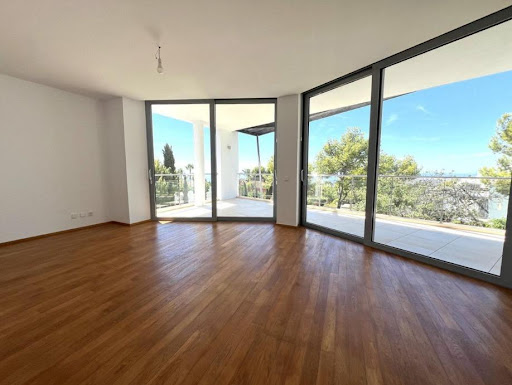 Modern living room with wood floor and large bay window in this luxury property for sale in Marbella ($3,470,214 - 728 m²)