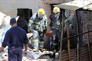 Firefighters attend to a scene where an old hijacked building, caught fire and collapsed on Kaal Street Jeppestown, Johannesburg. 