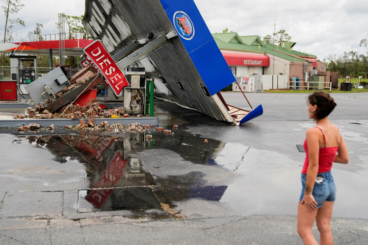 FILE PHOTO: Hope Laird looks at the wreckage of a gas station near her home after the arrival of Hurricane Idalia in Perry, Florida, U.S., August 30, 2023.