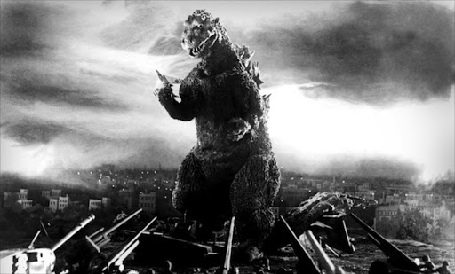 Godzilla faces an artillery battalion while grasping a doomed jet in the 1954 film.